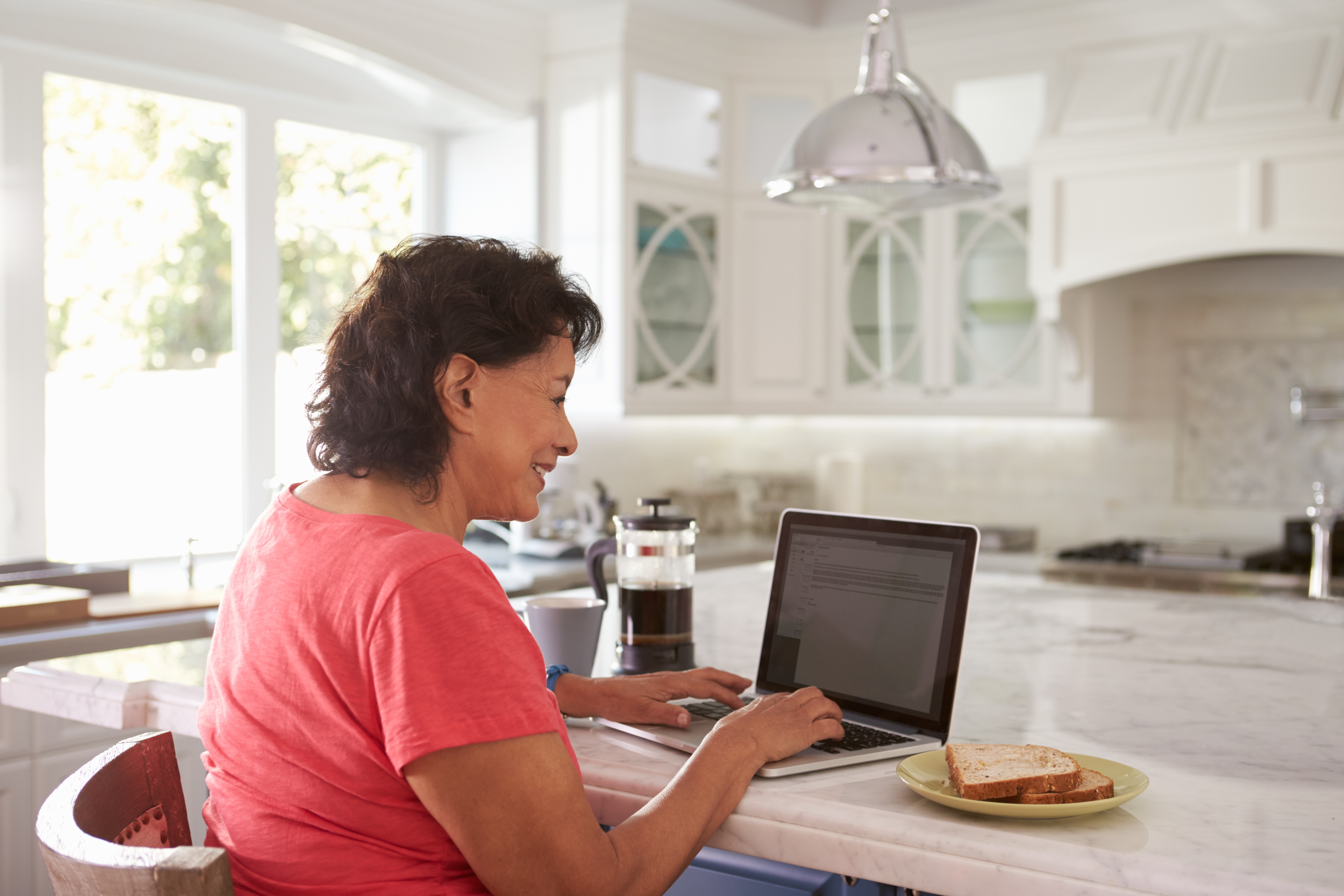 An Hispanic woman working on a laptop